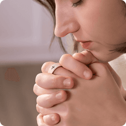 Eyes closed in prayer, the ring adds ritual and 